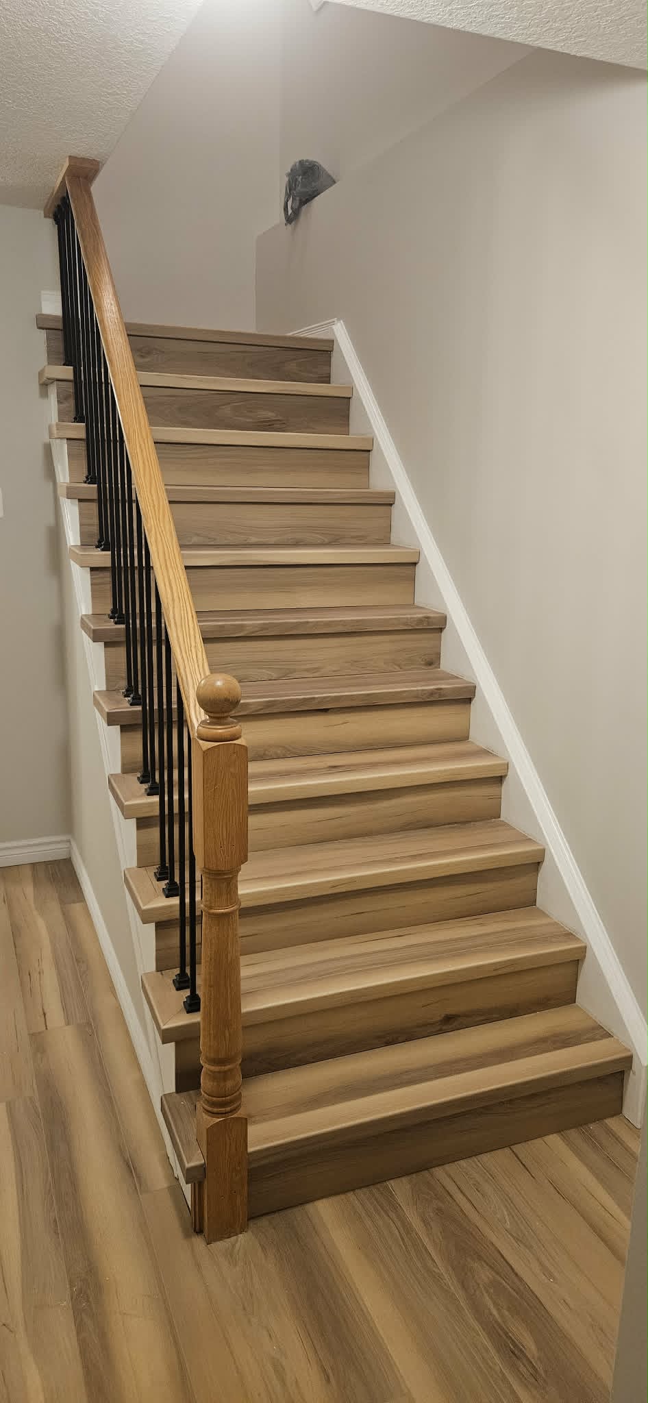 Refinished wood staircase with black metal balusters