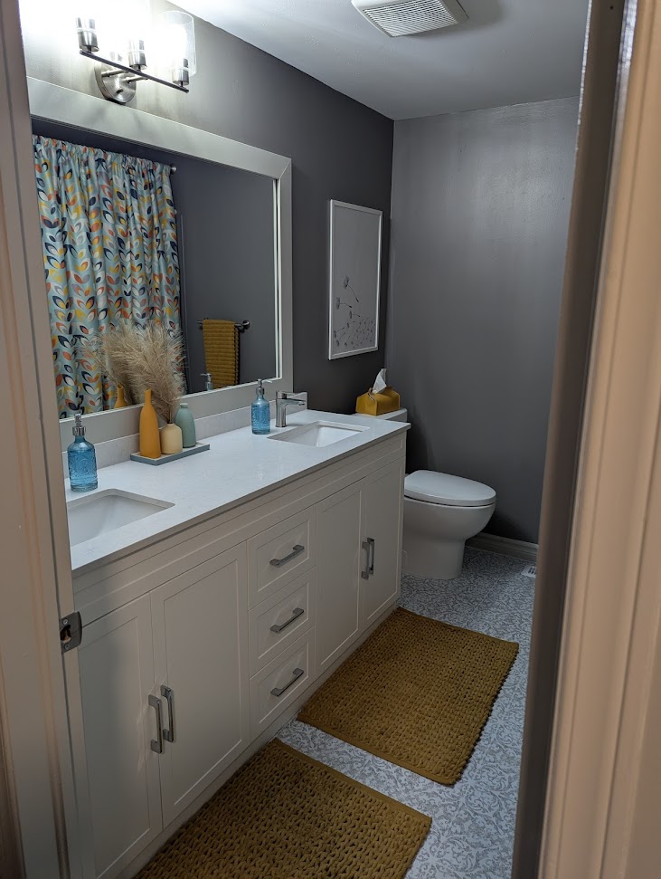 Finished bathroom with marble-look walls and black fixtures